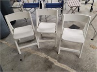 Three folding plastic chairs