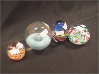 Four colored paperweights decorated with flowers,