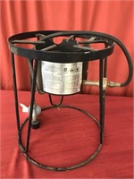 Portable outdoor cooker stand with propane hose.