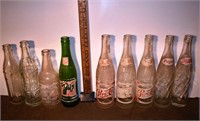 9 early glass soda bottles: Pepsi, 7-up, Frostie,