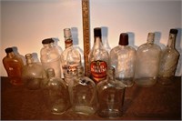 11 early mostly clear glass whiskey bottles; as is