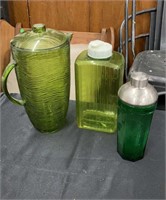 Two Green Plastic Pitchers with a Green Glass