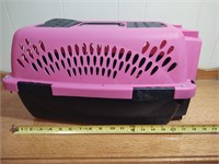 Small pink pet carrier with squeaky toys and