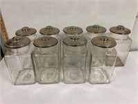 9 glass Canisters 10” tall. 5” square