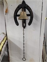 Brass doorbell with iron horseshoe wall bracket