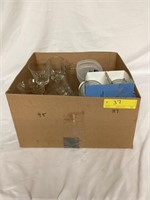 A box with wine glasses, water cups, scotch