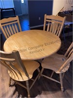 Round wooden dining table with four chairs