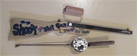 Wood decorative gun and stubby fishing reel.