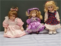 Three Dolls One Has Purple Dress With A Hat