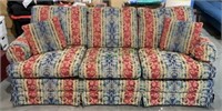 Three seat upholstered couch with throw pillows.