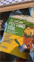 Shelf of potting soil and plastic bins with