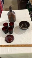 Vintage bottle, red glass cups, clay bowl.