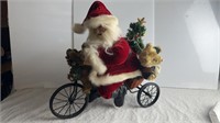 Vintage Santa on a  Tricycle with Basket of Toys.