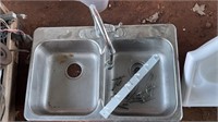 A STAINLESS STEEL DOUBLE SINK, ONE DRAIN GASKET