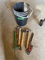 Hammers and pipe wrench in a pail