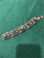 Gold bracelet with blue stones and pearl beads.