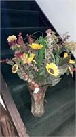 Faux sunflower arrangement in glass vase about