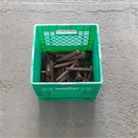 Green milk crate with 34 railroad spikes.