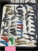 Collection of Miniature Toy Guns in Display Case.