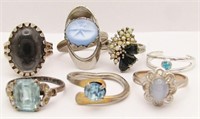 (7) SILVER TONE RINGS WITH BLUE GEMS