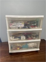Plastic sewing cabinet full of sewing  supplies