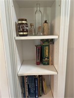 Large amount of books, bottles, cabinetry books