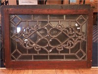 A beveled leaded glass window with wood frame,