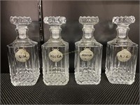 4 glass decanters with metal tags