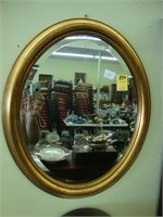 Oval gilt beveled wall mirror, 19” x 22".