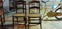 Two antique wooden chairs with cane seats.