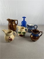 Ceramic pitchers, metal pitcher, and blue colored