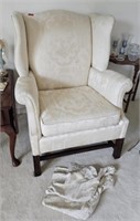 Cushioned occasional chair, wear on arms, has