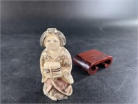 Ivory netsuke of a young woman with wood