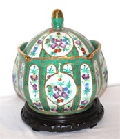 Asian porcelain covered jar on carved wooden base