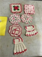 Seven crocheted pink and white potholders