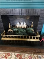 Ornate brass andirons and brass fireplace fender