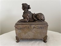 Vintage bronze Grecian Sphinx on an ornate wooden