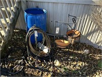 Garden hose, 2 standing planters, plastic barrel