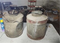Two old oil cans one is damaged.