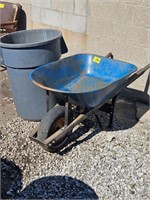 plastic trash can and metal wheelbarrow