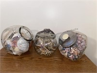 3 glass containers filled with seashells