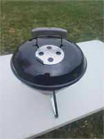 Small Weber charcoal grill.