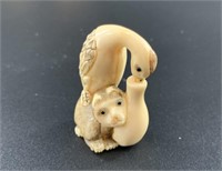 Antique mammoth netsuke of a monkey who is riding