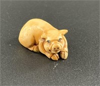Antique mammoth netsuke of a small pig curled up,