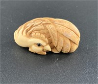 Antique mammoth netsuke of a sleepy roster curled