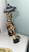 Pottery giraffe sculpture, relaxing in a chair