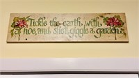 Painted wood sign that reads “tickle the earth