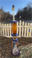 Tall, colored glass garden sculpture, with a