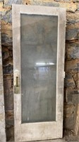 Large single pane glass door, with a large brass