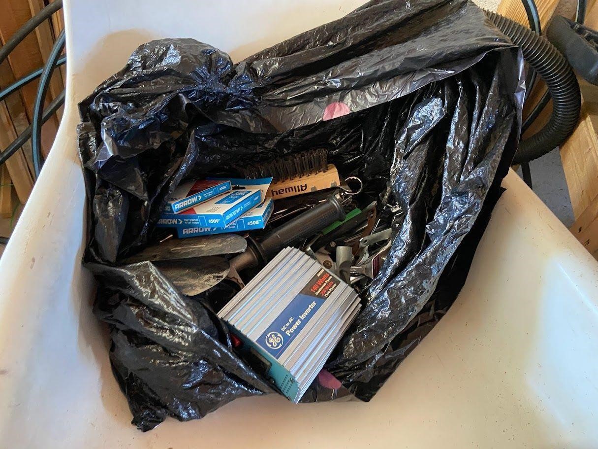 Black garbage bag filled with tools